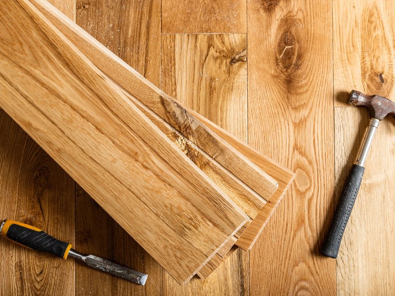 Hammer On A Pile Of Hardwood Planks from A Touch Of Magic Flooring in Emerald Isle, NC