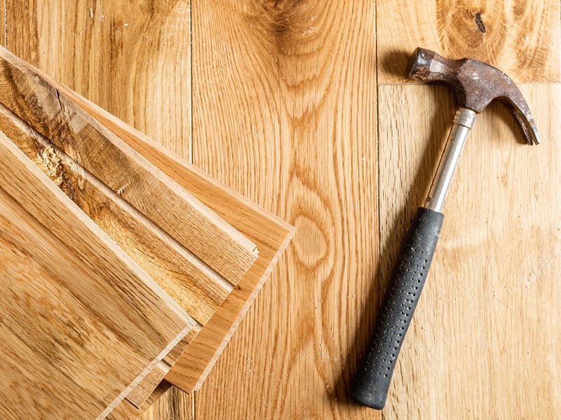 Hammer on pile of hardwood planks from A Touch Of Magic Flooring in Emerald Isle, NC