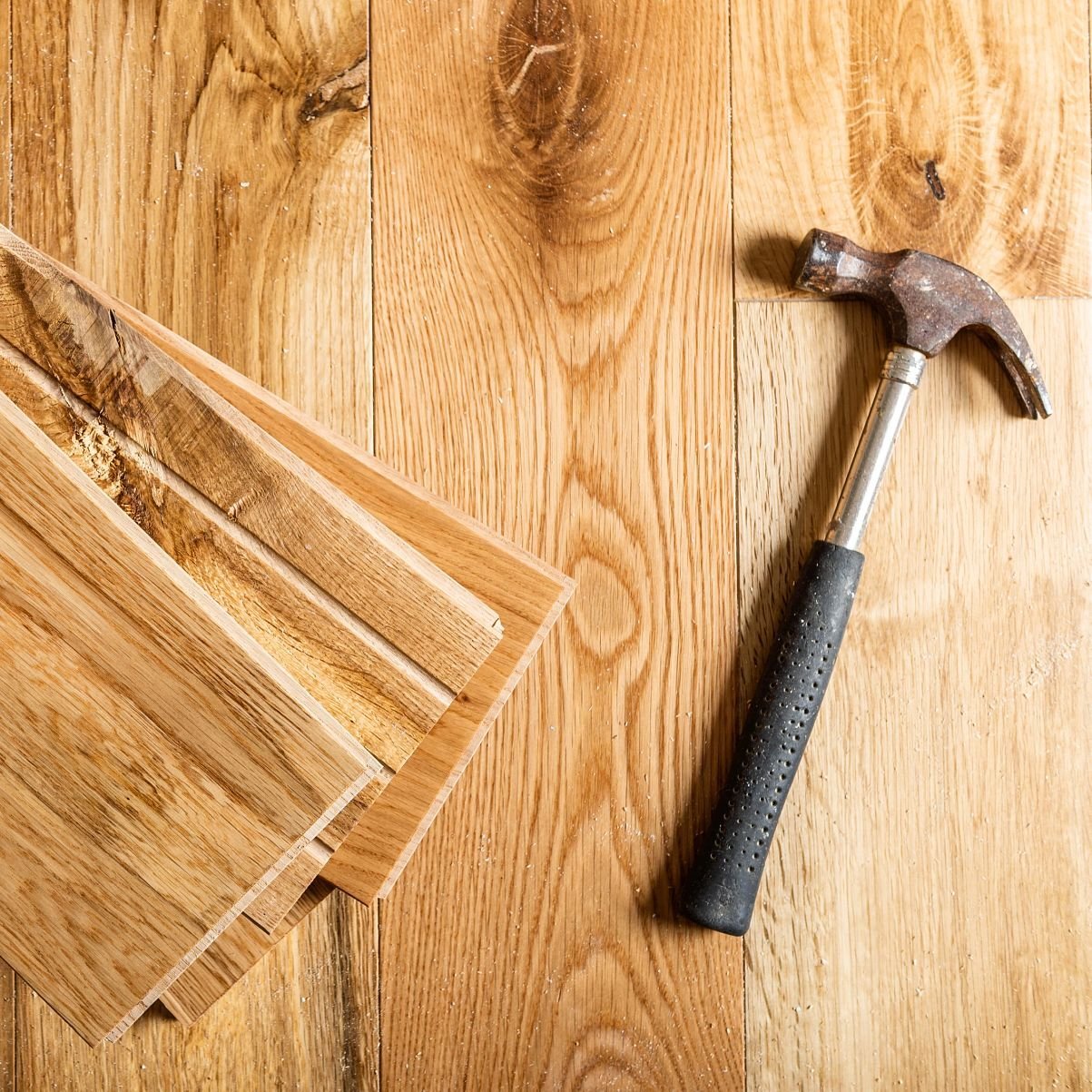 Hammer on pile of hardwood planks from A Touch Of Magic Flooring in Emerald Isle, NC