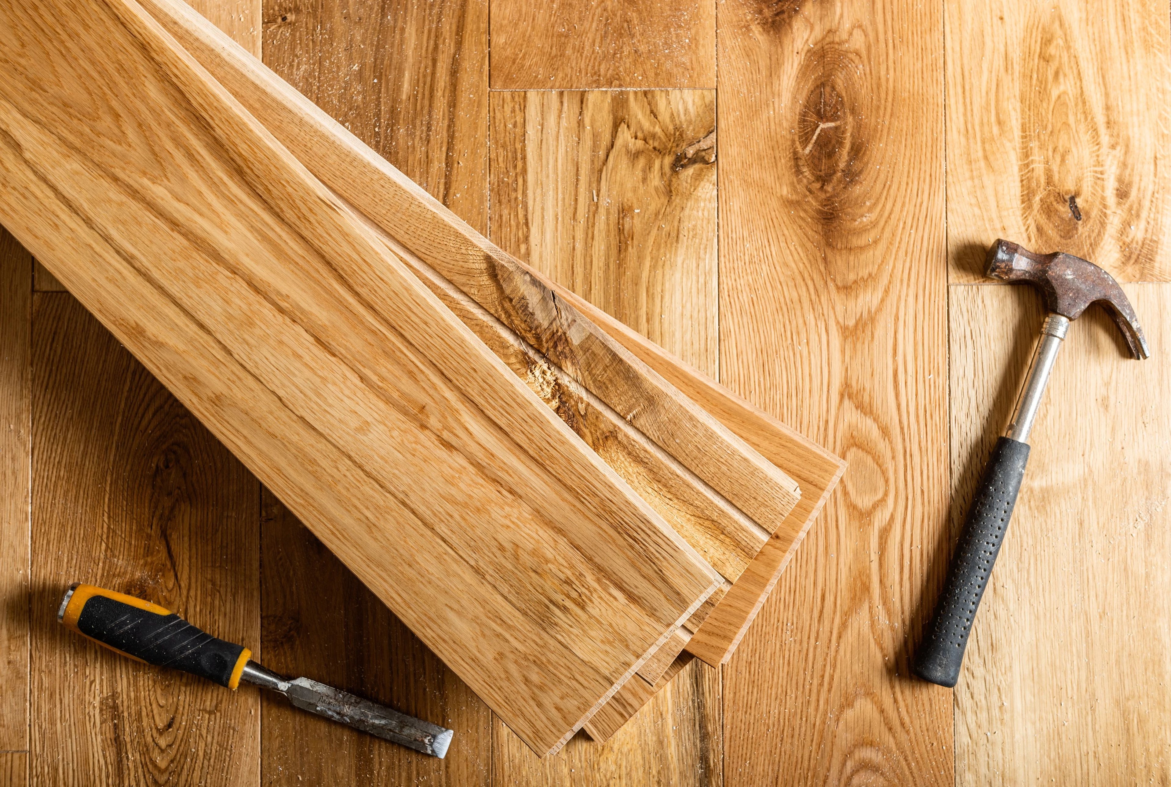 Hammer On A Pile Of Hardwood Planks from A Touch Of Magic Flooring in Emerald Isle, NC