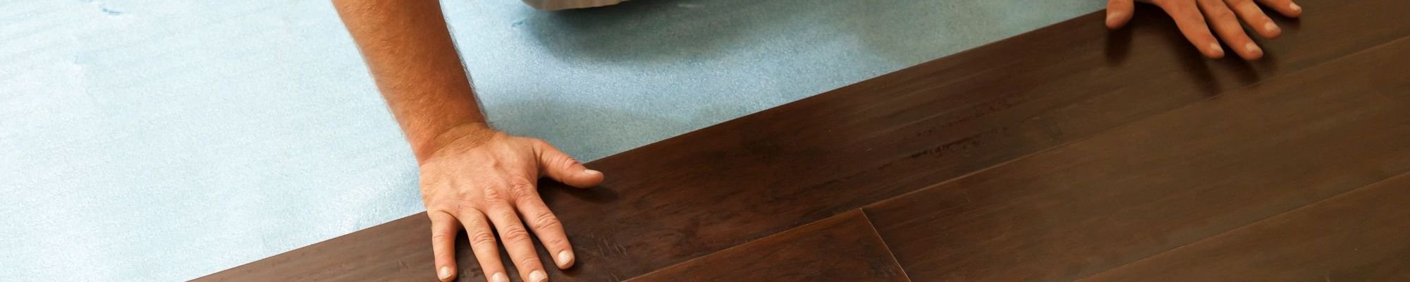 Person installing engineered hardwood flooring from A Touch Of Magic Flooring in Emerald Isle, NC