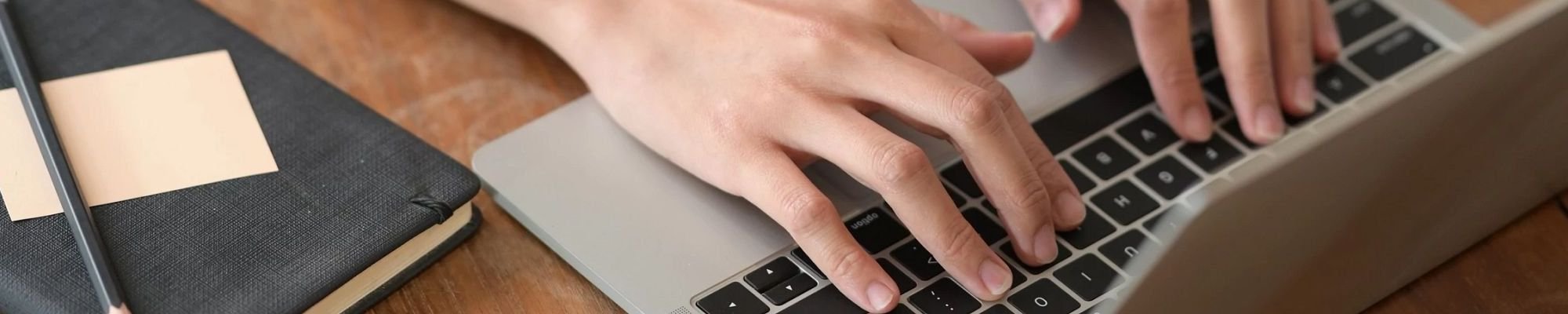 person typing at laptop from A Touch Of Magic Flooring in Emerald Isle, NC